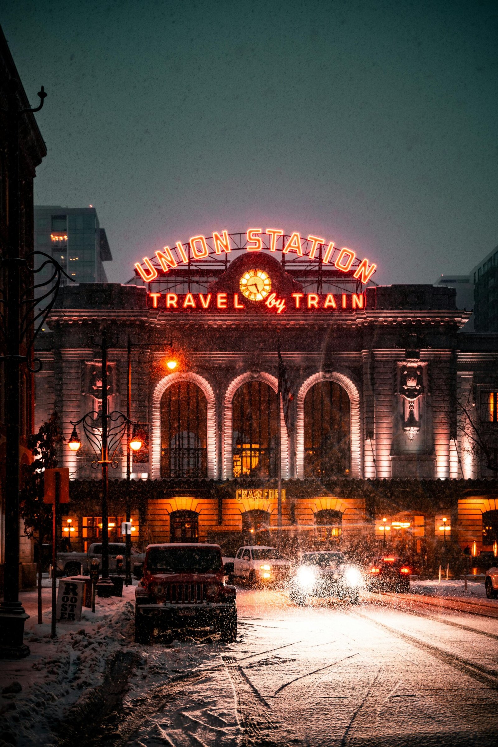 Illuminated Denver Union Station in snowfall, highlighting urban winter charm.